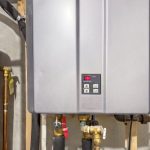 Tankless water heater installation with digital control panel and connected plumbing, illustrating modern efficiency for home hot water systems.